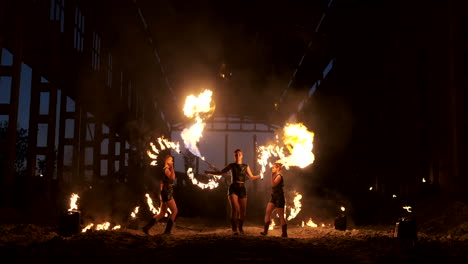 Slow-motion:-Fire-show-in-the-hangar-show-three-female-artist-and-a-man-with-flamethrowers